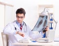 Young handsome doctor working in hospital room