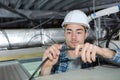 Young handsome electrician wiring inside ceiling Royalty Free Stock Photo