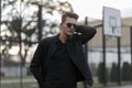 Young handsome fashion man with sunglasses in a black jacket Royalty Free Stock Photo