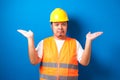 Young handsome fat asian worker man wearing orange safety vest uniform and helmet clueless and confused expression Royalty Free Stock Photo