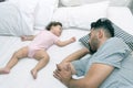 Young handsome father tired sleeping withone year baby girl. Bearded dad sleeps with baby in bed. Little newborn child in white Royalty Free Stock Photo