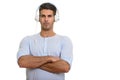 Young handsome fit Persian man listening to music with arms cros