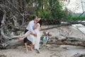 Young handsome groom holds his bride in his arms on the beach with a big bouquet of beautiful flowers Royalty Free Stock Photo