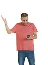 Young handsome guy acting surprised by a message on his mobile phone Royalty Free Stock Photo