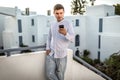 Young handsome guy, man businessman, freelancer, IT specialist with a mobile phone in Italy, Cyprus, Greece Royalty Free Stock Photo