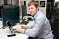 Young handsome happy man with computer in the office. Programmin Royalty Free Stock Photo