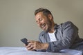 Young handsome and happy man at home using internet mobile phone on bed smiling cheerful and satisfied feeling relaxed dating Royalty Free Stock Photo