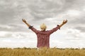 Young handsome happy man standing in wheat field spreading his arms up Royalty Free Stock Photo