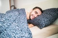 Young handsome happy man waking up on bed at home Royalty Free Stock Photo