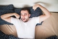 Young handsome happy man waking up on bed at home, top view Royalty Free Stock Photo