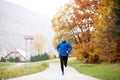 Young handsome hipster athlete running against colorful autumn n Royalty Free Stock Photo