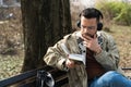 Young handsome hipster freelance business man wearing jacket reading a book while sitting outdoors. Businessperson on lunch break Royalty Free Stock Photo