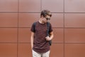 Young handsome hipster man with a fashionable hairstyle in shorts in black stylish sunglasses in a vintage T-shirt Royalty Free Stock Photo