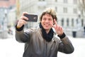 Young handsome hipster man making funny selfie