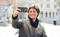 Young handsome hipster man making funny selfie