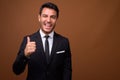 Young handsome Hispanic businessman against brown background Royalty Free Stock Photo