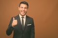 Young handsome Hispanic businessman against brown background Royalty Free Stock Photo