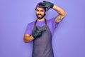 Young handsome hispanic man with bear wearing professional apron working as tattoo artist smiling making frame with hands and Royalty Free Stock Photo