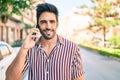 Young handsome hispanic man with beard smiling happy outdoors speaking on the phone Royalty Free Stock Photo