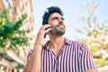 Young handsome hispanic man with beard smiling happy outdoors speaking on the phone Royalty Free Stock Photo