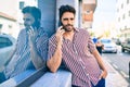 Young handsome hispanic man with beard smiling happy outdoors speaking on the phone Royalty Free Stock Photo