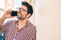 Young handsome hispanic man with beard smiling happy outdoors speaking on the phone Royalty Free Stock Photo