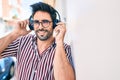 Young handsome hispanic man with beard smiling happy outdoors wearing headphones listening to music Royalty Free Stock Photo