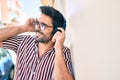 Young handsome hispanic man with beard smiling happy outdoors wearing headphones listening to music Royalty Free Stock Photo