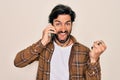 Young handsome hispanic man having a conversation talking on smartphone screaming proud and celebrating victory and success very Royalty Free Stock Photo
