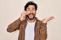 Young handsome hispanic man having a conversation talking on smartphone very happy and excited, winner expression celebrating Royalty Free Stock Photo