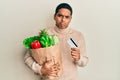 Young handsome hispanic man holding groceries and credit card depressed and worry for distress, crying angry and afraid Royalty Free Stock Photo