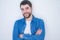 Young handsome hispanic man smiling at the camera with arms crossed looking happy and confident over isolated white background Royalty Free Stock Photo