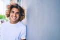 Young handsome hispanic man smiling happy leaning on the wall at street of city Royalty Free Stock Photo