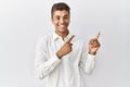 Young handsome hispanic man standing over isolated background smiling and looking at the camera pointing with two hands and Royalty Free Stock Photo
