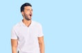 Young handsome hispanic man wearing casual clothes angry and mad screaming frustrated and furious, shouting with anger Royalty Free Stock Photo