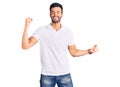 Young handsome hispanic man wearing casual clothes dancing happy and cheerful, smiling moving casual and confident listening to Royalty Free Stock Photo