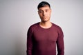 Young handsome hispanic man wearing casual shirt standing over white isolated background depressed and worry for distress, crying Royalty Free Stock Photo