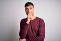 Young handsome hispanic man wearing casual shirt standing over white isolated background with hand on chin thinking about Royalty Free Stock Photo