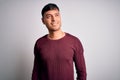 Young handsome hispanic man wearing casual shirt standing over white isolated background looking away to side with smile on face, Royalty Free Stock Photo