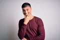 Young handsome hispanic man wearing casual shirt standing over white isolated background looking confident at the camera smiling Royalty Free Stock Photo