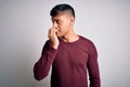 Young handsome hispanic man wearing casual shirt standing over white isolated background looking stressed and nervous with hands Royalty Free Stock Photo