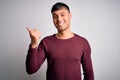 Young handsome hispanic man wearing casual shirt standing over white isolated background smiling with happy face looking and Royalty Free Stock Photo