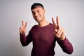 Young handsome hispanic man wearing casual shirt standing over white isolated background smiling looking to the camera showing Royalty Free Stock Photo