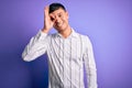 Young handsome hispanic man wearing elegant business shirt standing over purple background doing ok gesture with hand smiling, eye Royalty Free Stock Photo