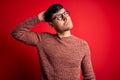 Young handsome hispanic man wearing nerd glasses over red background confuse and wondering about question Royalty Free Stock Photo