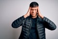 Young handsome hispanic man wearing winter coat standing over white isolated background suffering from headache desperate and Royalty Free Stock Photo