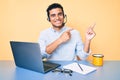 Young handsome hispanic man working at the office wearing operator headset smiling and looking at the camera pointing with two Royalty Free Stock Photo