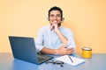 Young handsome hispanic man working at the office wearing operator headset smiling looking confident at the camera with crossed Royalty Free Stock Photo