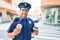 Young handsome hispanic policeman wearing police uniform smiling happy