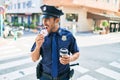 Young handsome hispanic policeman wearing police uniform smiling happy